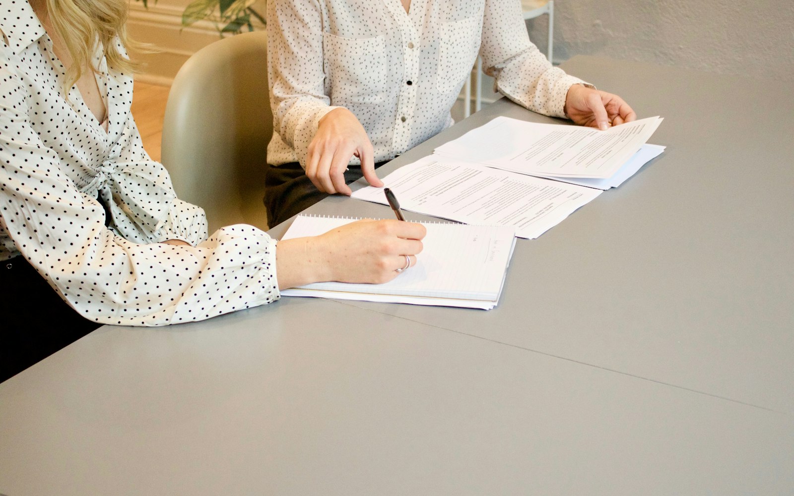 Two people reviewing and signing paperwork at a table