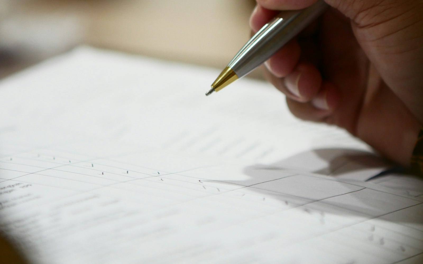 A hand holding a pen over a document