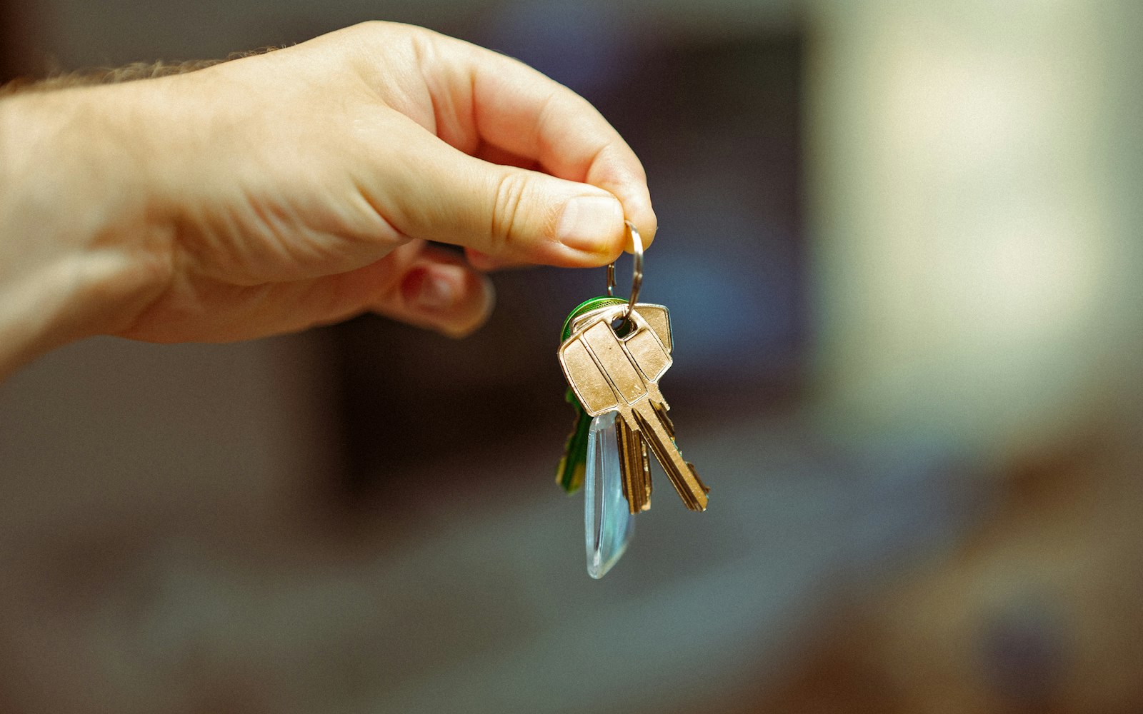 A hand holding a set of house keys
